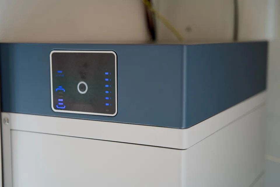 A home battery storage unit with an illuminated status display.