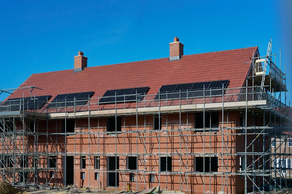 New brick homes with rooftop solar panels during construction.